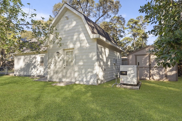 rear view of property with a shed and a lawn