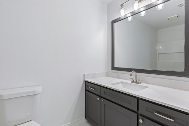 bathroom featuring a shower, vanity, and toilet