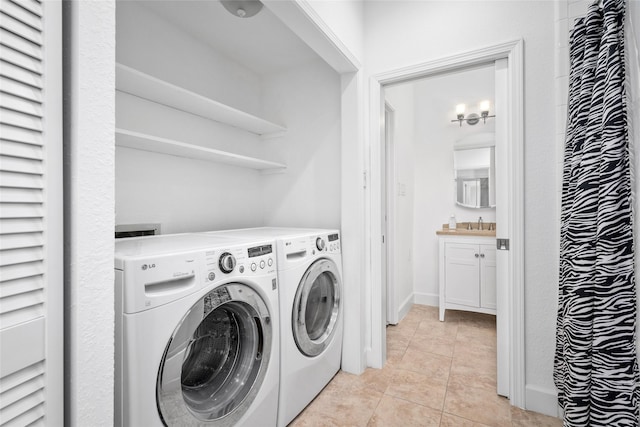 laundry area featuring a notable chandelier, light tile patterned floors, sink, and washing machine and clothes dryer