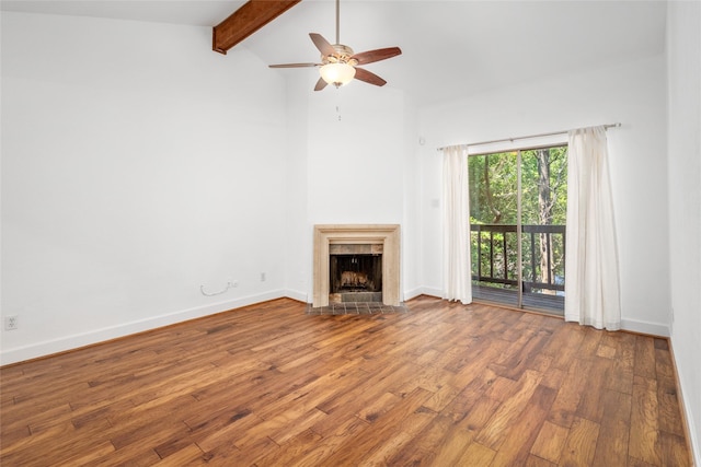 unfurnished living room with a tile fireplace, hardwood / wood-style floors, vaulted ceiling with beams, and ceiling fan