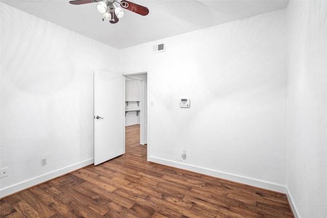 spare room featuring ceiling fan and dark wood-type flooring