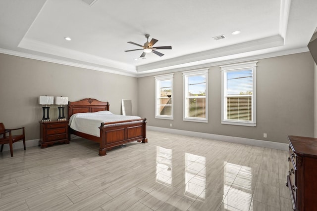 bedroom featuring ceiling fan, crown molding, and a tray ceiling