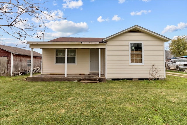 rear view of property featuring a yard