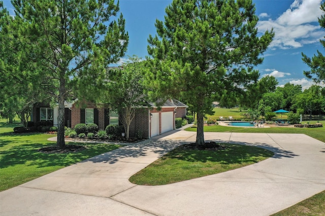 obstructed view of property featuring a garage and a front yard