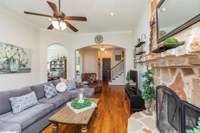 living room with ceiling fan, ornamental molding, dark hardwood / wood-style floors, and a fireplace