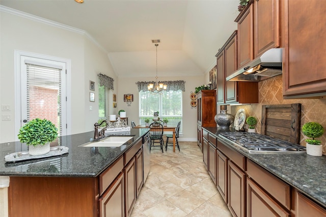 kitchen with appliances with stainless steel finishes, lofted ceiling, an island with sink, decorative backsplash, and sink