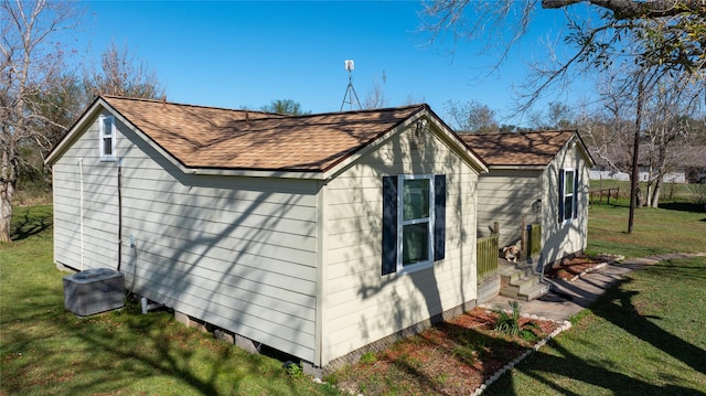 view of outbuilding with cooling unit and a yard