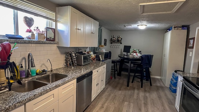 kitchen featuring sink, stainless steel appliances, white cabinetry, and a textured ceiling