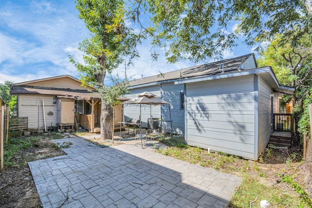 rear view of property with a gazebo, a patio area, and central AC