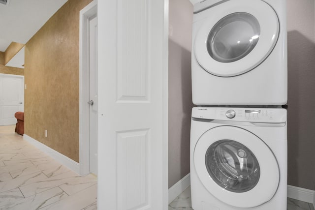 clothes washing area featuring stacked washer and clothes dryer