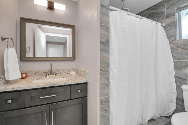 bathroom featuring vanity, toilet, and curtained shower