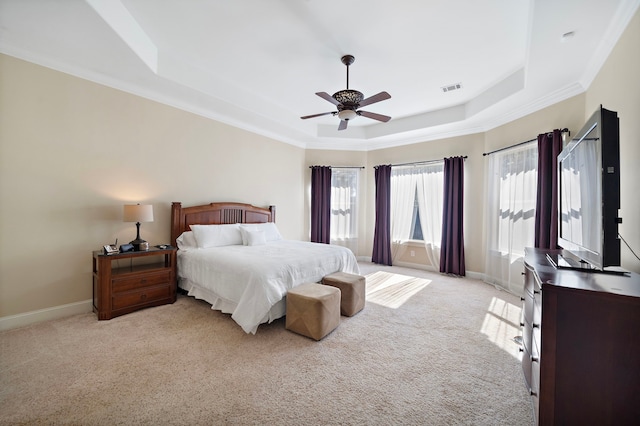 carpeted bedroom featuring a raised ceiling, ceiling fan, and ornamental molding