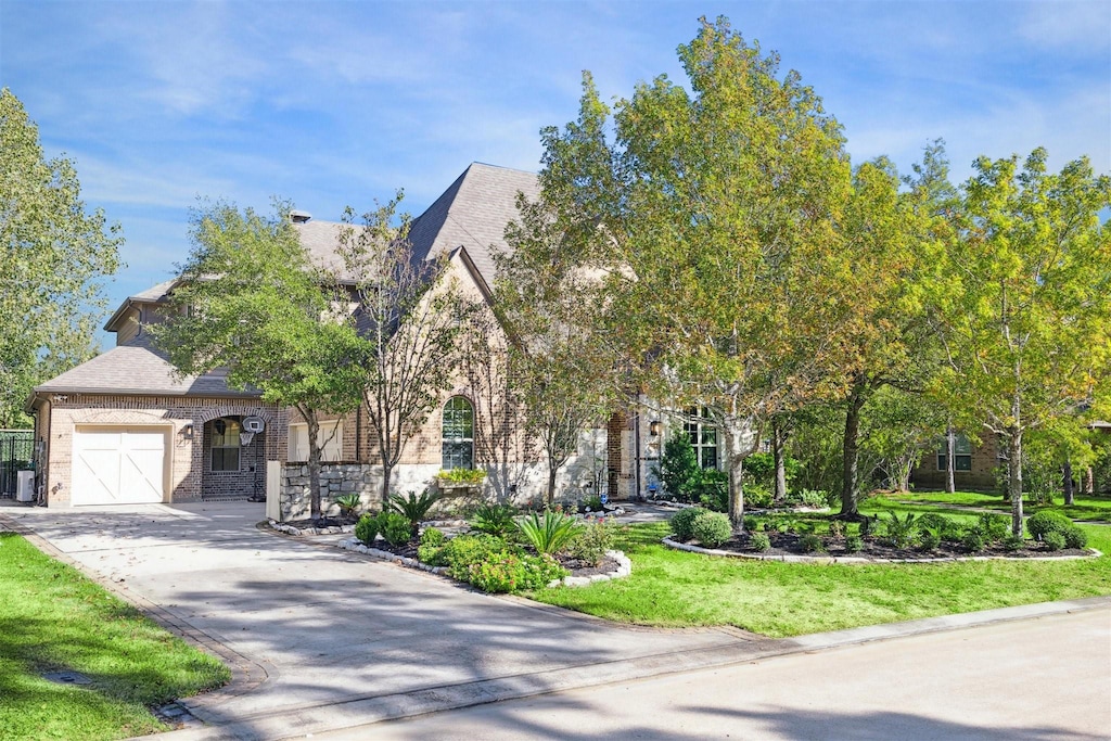 view of property hidden behind natural elements with central air condition unit and a garage