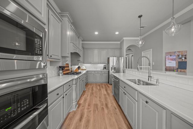 kitchen with stainless steel appliances, tasteful backsplash, gray cabinetry, and sink