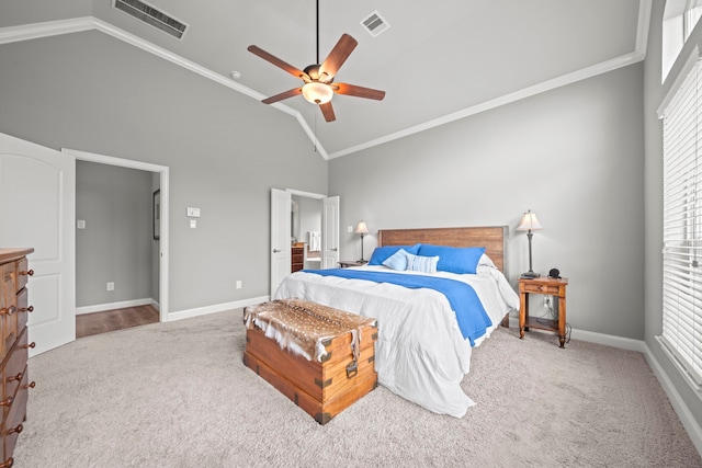 carpeted bedroom with ceiling fan, crown molding, and vaulted ceiling