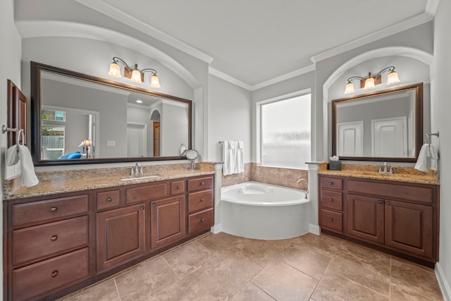 bathroom featuring a bathing tub, vanity, plenty of natural light, and crown molding