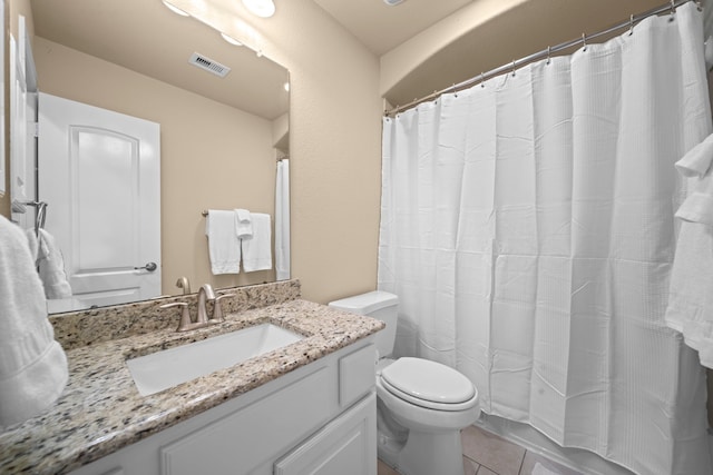 bathroom with tile patterned flooring, vanity, and toilet