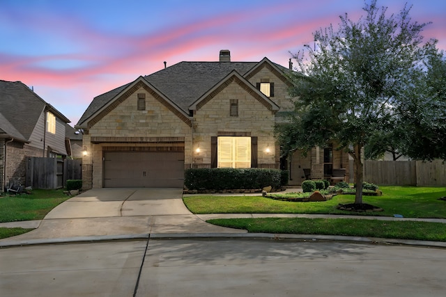 view of front of house with a garage and a lawn