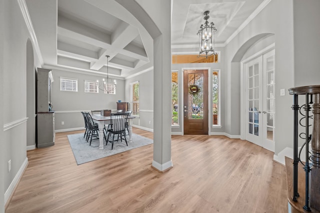 entrance foyer with french doors, a notable chandelier, coffered ceiling, and beam ceiling