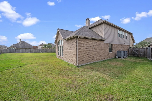 back of property featuring a lawn and central AC