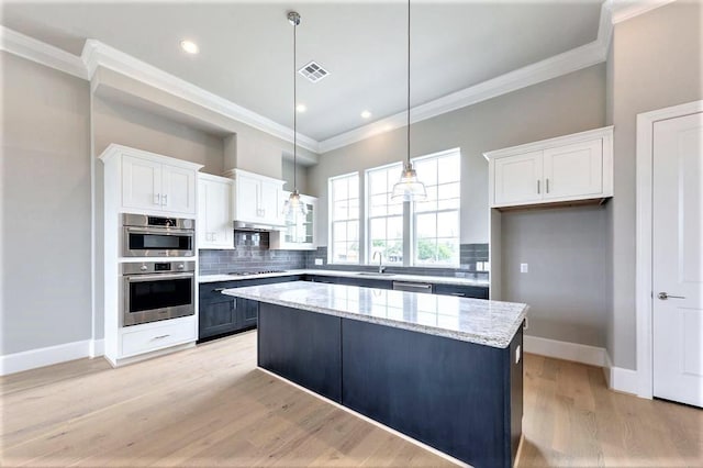 kitchen with a center island, decorative light fixtures, white cabinetry, and sink