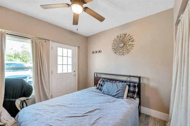 bedroom featuring hardwood / wood-style flooring, ceiling fan, and a textured ceiling