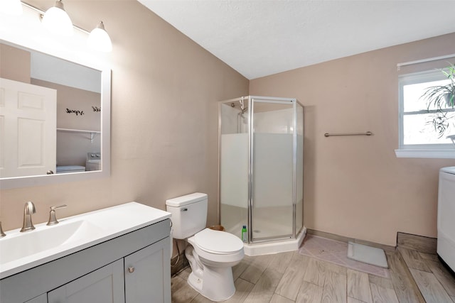 bathroom with toilet, vanity, vaulted ceiling, and a shower with door