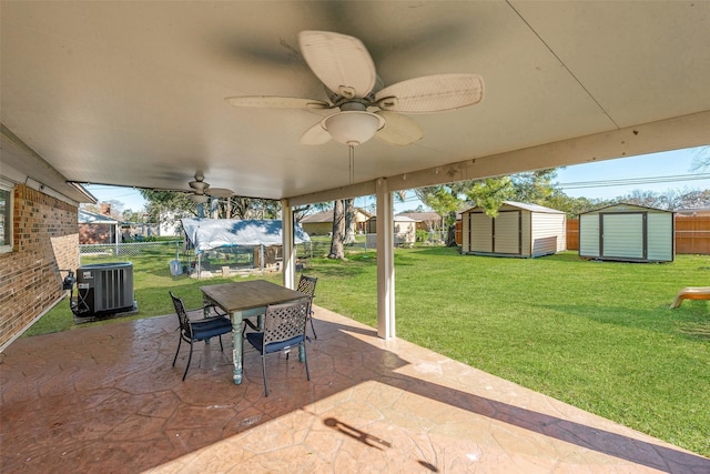 view of patio with ceiling fan, central AC unit, and a shed