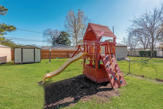 view of play area featuring a lawn and a storage unit