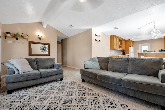 living room with hardwood / wood-style floors, lofted ceiling with beams, a textured ceiling, and a notable chandelier