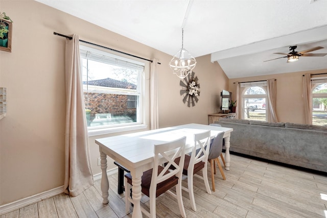 dining area with plenty of natural light, ceiling fan with notable chandelier, and vaulted ceiling