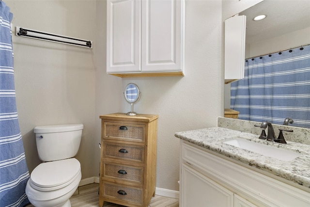 bathroom with wood-type flooring, toilet, and vanity