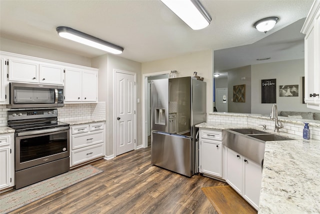 kitchen with tasteful backsplash, sink, white cabinetry, stainless steel appliances, and light stone counters