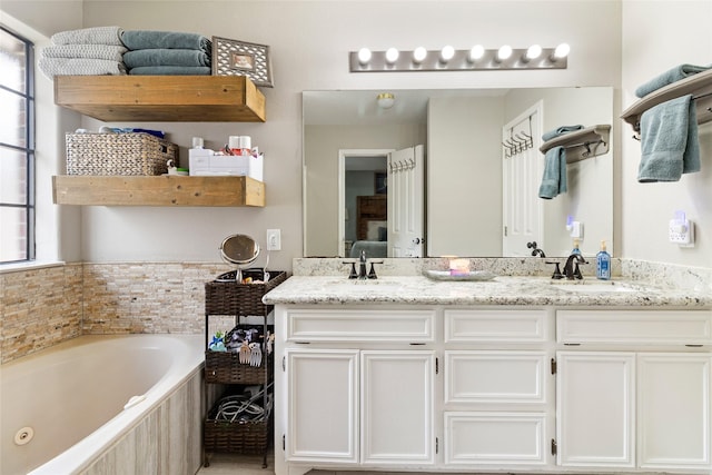 bathroom with tiled tub and vanity