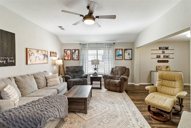 living room featuring ceiling fan, vaulted ceiling, a textured ceiling, and hardwood / wood-style floors