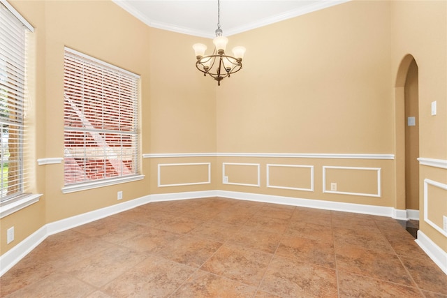 empty room featuring a notable chandelier and ornamental molding