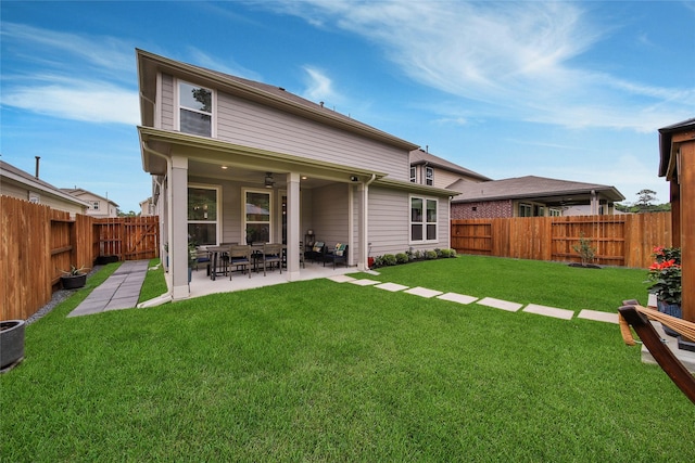 rear view of property with a yard and a patio area