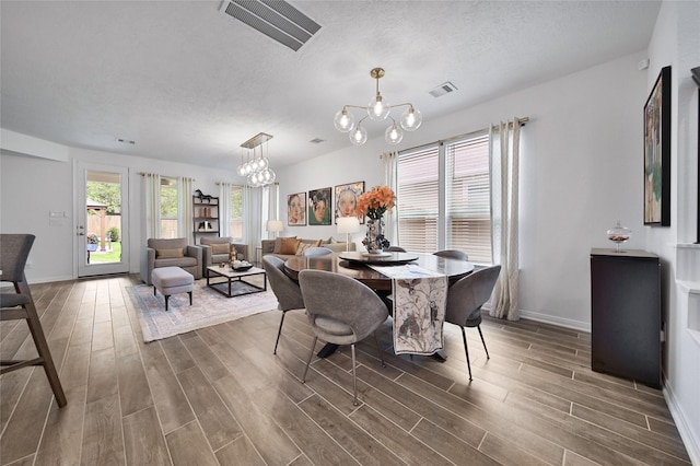 dining room featuring an inviting chandelier, dark hardwood / wood-style floors, and a textured ceiling