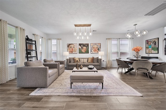 living room with an inviting chandelier and a textured ceiling