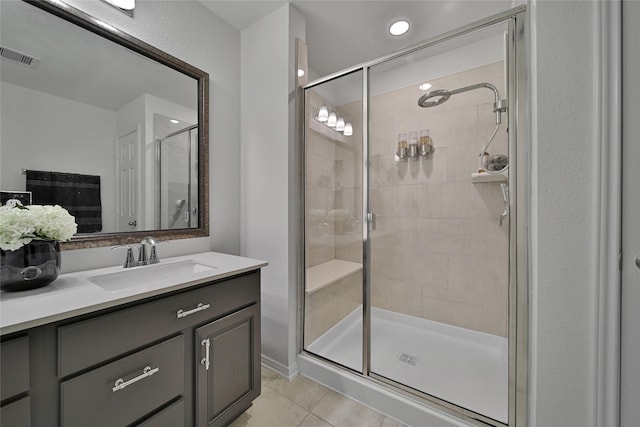 bathroom featuring vanity, a shower with shower door, and tile patterned floors