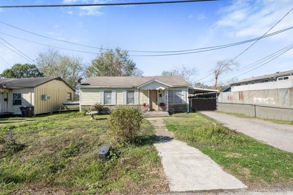 bungalow-style home with a front lawn and a carport