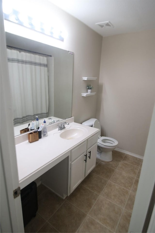 bathroom featuring tile patterned floors, vanity, and toilet