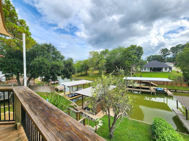 view of dock with a yard and a water view