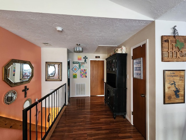 corridor featuring dark hardwood / wood-style floors and a textured ceiling