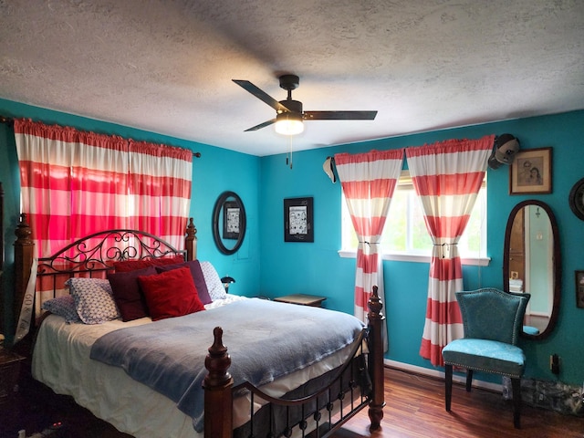 bedroom featuring ceiling fan, wood-type flooring, and a textured ceiling