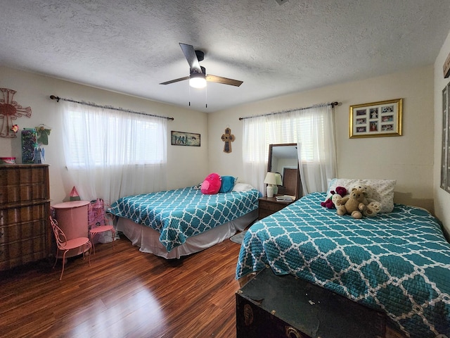 bedroom featuring ceiling fan, dark wood-type flooring, and a textured ceiling