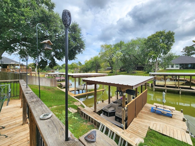 view of dock with a lawn and a water view