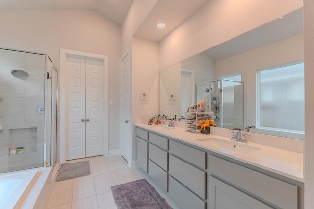 bathroom with tile patterned floors, vanity, separate shower and tub, and lofted ceiling