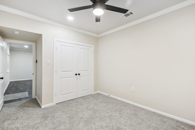 unfurnished bedroom featuring carpet flooring, a closet, ceiling fan, and crown molding