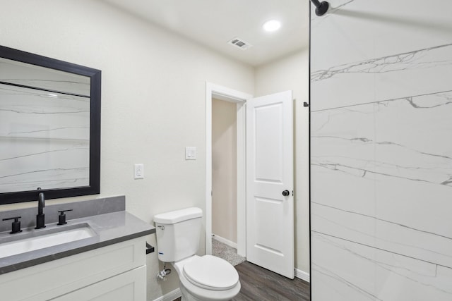 bathroom featuring vanity, wood-type flooring, and toilet